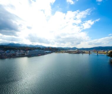 Wide river with bridge and town seen from caffel Hina-no-sato in Oita