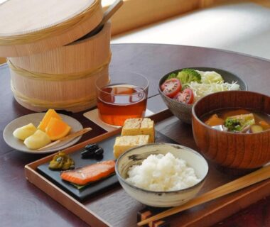 Wooden tray with rice, grilled fish, tamagoyaki, miso soup and pickles on low table at ryokan in Asakusa Tokyo