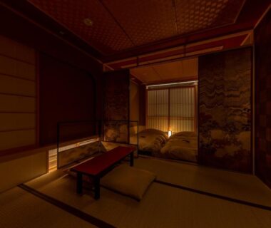 Dimly lit tatami room with low table, zabuton cushions and futon near shoji screens at cyashitsu ryokan asakusa in Tokyo