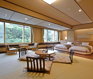 Tatami room with low table, floor chairs and twin beds at jyozankei SHIKAnoYU in Hokkaidō Japan