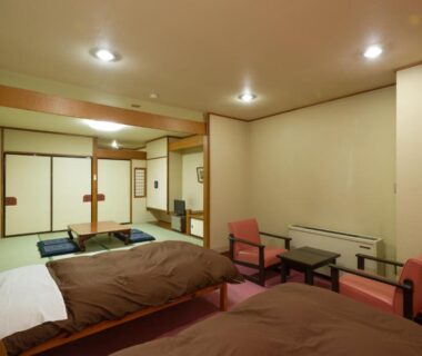 Tatami room with low table, chairs and twin beds at kinugawaonsen Fukumatsu, Tochigi