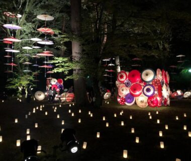 Night garden with hanging paper umbrellas and ground lanterns at kinugawaonsen Fukumatsu in Tochigi