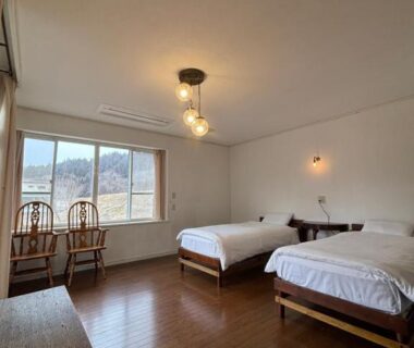 Twin beds on wooden floor with window seating at Koyado Kaziya, Iwate, Tohoku