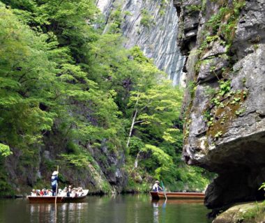 Wooden boats drifting through a rocky forest gorge near Koyado Kaziya Iwate Tōhoku