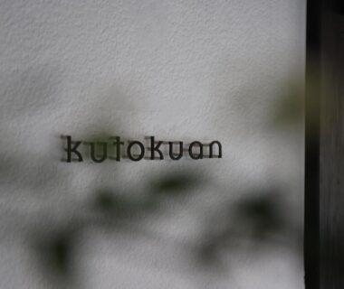 White textured wall with kutokuan lettering and blurred foliage at entrance, Gifu, Chūbu, Japan