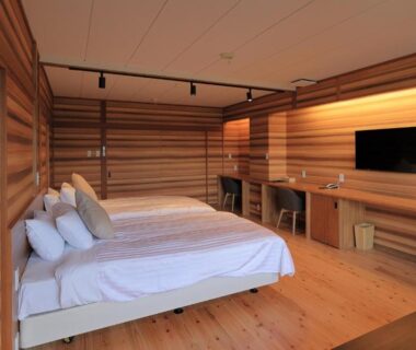 Wood-paneled guest room with twin beds, TV and desk at mt. inn in Fukushima, Tōhoku