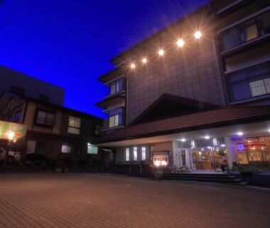 Night exterior of mt. inn building in Fukushima with illuminated entrance and paved forecourt