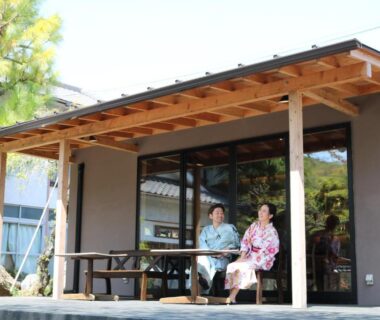 Two guests in yukata seated on wooden engawa porch with low table at nanaougi in Kanagawa