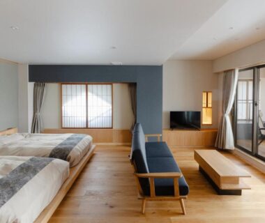 Twin beds, wooden interior, shoji window and balcony seating at onogawaonsen azumasou Yamagata