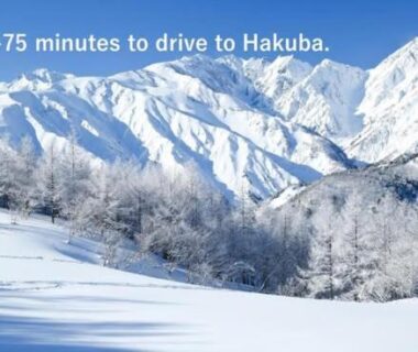 Snow-covered mountain landscape with frosted trees and text noting drive time to Hakuba, Nagano