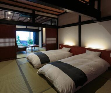 Tatami room with futon beds and shoji screens, sliding doors to veranda at ryugon Niigata
