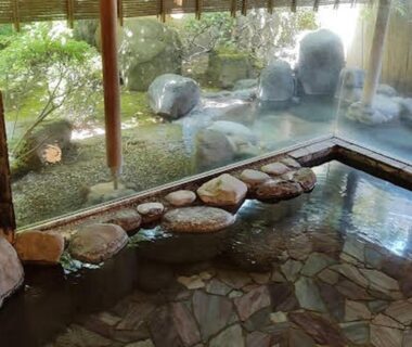 Stone and tiled onsen bath beside a rock garden at soraichi in Miyagi Tōhoku