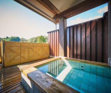 Outdoor tiled bath with wooden deck and privacy panels at Chalet de montagne Hibari d’Asagiri in Kumamoto