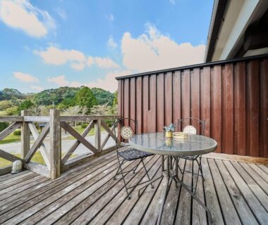 Wooden deck with round table and metal chairs at Chalet de montagne Hibari d’Asagiri, Kumamoto, Kyūshū, Japan