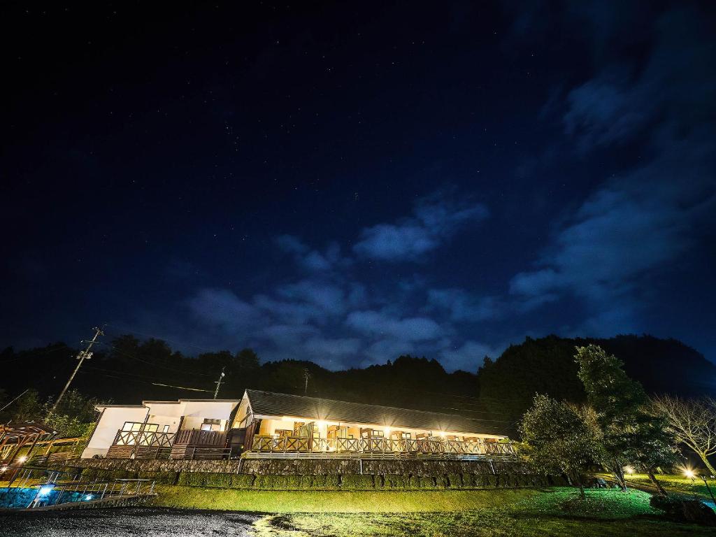 Night exterior Chalet de montagne Hibari d’Asagiri Kumamoto Warmly lit ryokan building at night with mountain silhouette, Chalet de montagne Hibari d’Asagiri, Kumamoto, Kyūshū