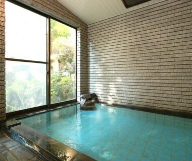 Tiled indoor bath with spout and garden view through window at Kintoki Sanso in Hakone, Kanagawa