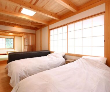Japanese-style room with shoji screens, wooden ceiling, tatami area and twin beds at Utsuboya-sō Tokyo
