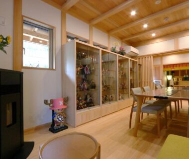 Warm wooden interior with glass display cabinets, dining table and chairs at Utsuboya-sō in Tokyo