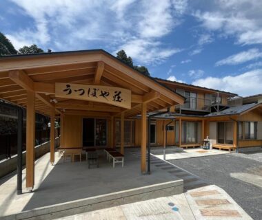 Entrance canopy and outdoor seating at Utsuboya-sō in Tokyo with wooden facades and courtyard