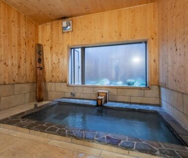 Indoor wooden-walled stone-edged onsen bath at Uribō Ryokan Nakamichi Urabō in Gunma, Kantō