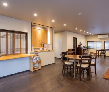 Reception and seating area with wooden floors and lattice windows at Uribō Ryokan Nakamichi in Gunma, Japan