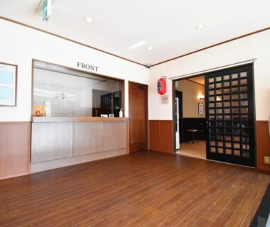Reception area at Oyado Kokoro in Gifu with wooden floor, front desk and lattice sliding door