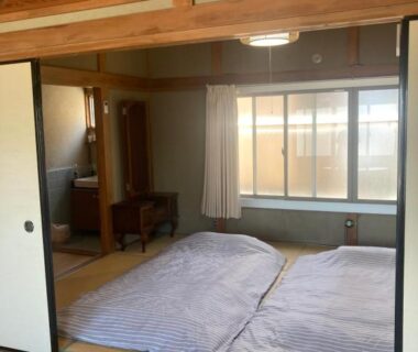 Tatami room with two futons and fusuma doors at Oyado et table Momo in Wakayama