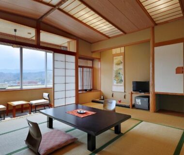 Traditional tatami room with low table, zabuton cushions, shoji screens and window seat overlooking Miyagi mountain view
