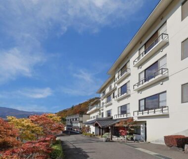 White multi-story ryokan building with autumn foliage by driveway, Ryokan Sanjirō, Miyagi Tōhoku