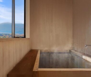 Indoor wooden bath with window view of distant mountains at Ryokan Sanjirō in Miyagi, Tōhoku
