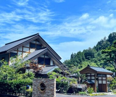 Traditional ryokan exterior with landscaped greenery and mountain backdrop at Suikōen Sakura, Shizuoka, Chūbu Japan