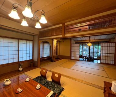 Spacious tatami room with shoji screens, low dining table and seating cushions at Suikōen Sakura in Chūbu, Japan