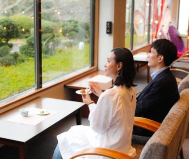 Two guests in robes enjoying tea by window overlooking garden at Miharu-en Nara