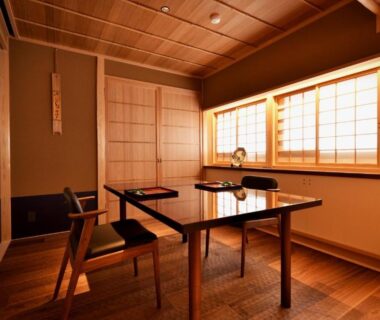 Tatami room with low dining table, chairs and shoji screens at Tsurukō in Ishikawa