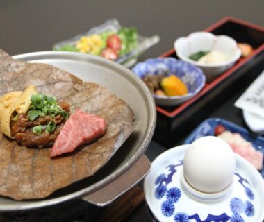 Grilled meat on a large leaf with assorted side dishes at Hirayunomori Bettei Yuuka Sanzōan in Gifu, Chūbu