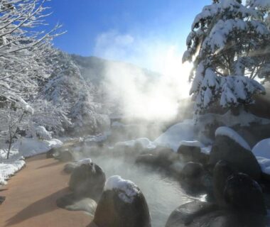 Steaming outdoor onsen among snow-covered rocks and trees at Hirayunomori Bettei Yuuka Sanzōan, Gifu, Chūbu