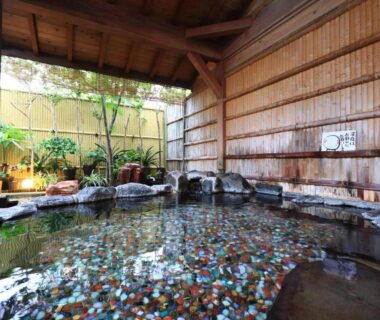 Covered stone onsen with bamboo walls and pebbled floor at Fukabe, Shizuoka