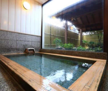 Wood-framed indoor bath overlooking a small garden at Fukabe ryokan, Shizuoka