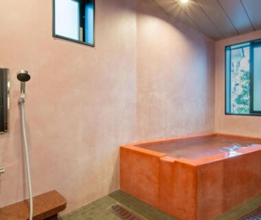 Indoor rectangular soaking tub with hand shower and small window at Yanagi-sō in Hyōgo, Kansai