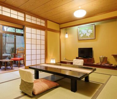 Traditional tatami room with low table, floor chairs, shoji screens and a small veranda with seating