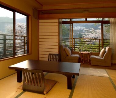 Tatami room with low table, shoji screens and window seating at Auberge Hanagoyomi, Shizuoka hillside view