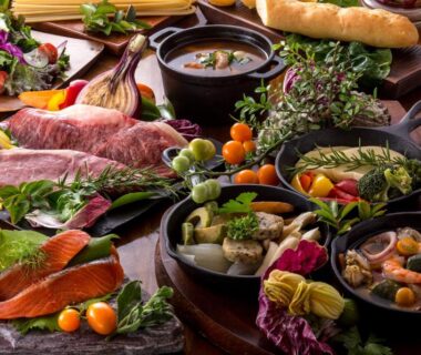 Assorted dinner spread at Grandome Fuji Oshino with sliced fish, grilled meat, vegetables, bread and wine