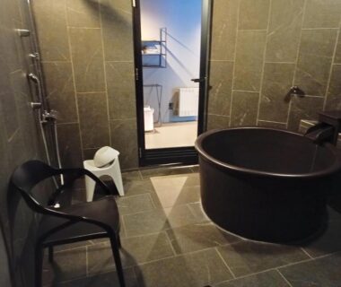 Round soaking tub and shower in tiled bathroom at Glamping Village Fuji Kawaguchiko Yamanashi