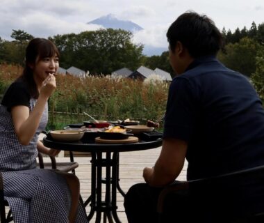 Couple dining on outdoor terrace with glamping tents, Glamping Village Fuji Kawaguchiko, Yamanashi Japan