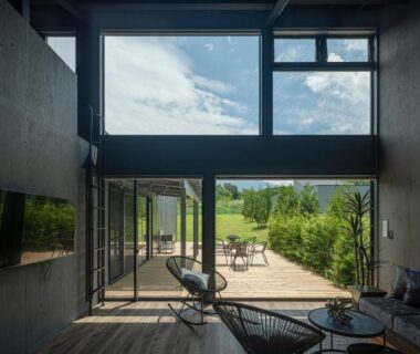 Spacious lounge with floor-to-ceiling windows opening to wooden terrace at Glamping Village Fuji Kawaguchiko, Yamanashi