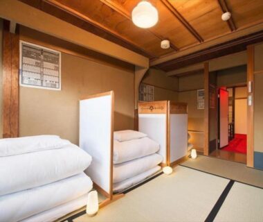 Folded futon bedding and shoji-style dividers in a tatami room at Dozen Ryokan, Kyoto