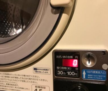 Close-up of coin-operated dryer control panel showing 30-minute 100 yen at Dozen Ryokan Kyoto laundry