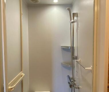 Enclosed unit shower with handheld showerhead, wall shelf and fold-down seat in Hitotsuru ryokan bathroom, Setouchi Hiroshima