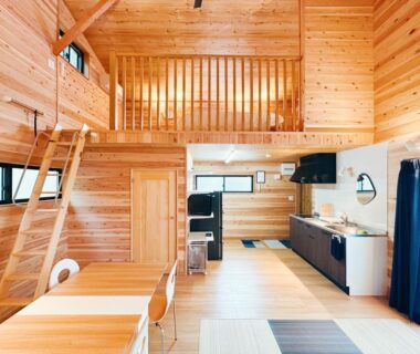 Sunlit wood-paneled loft with ladder, dining table and kitchenette at Hitotsuru, Hiroshima
