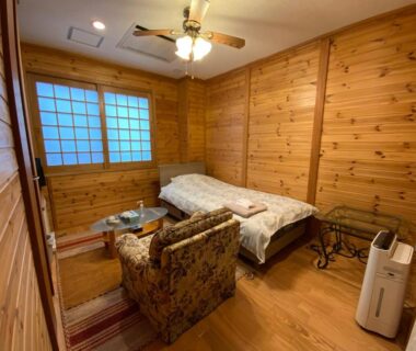 Cozy wood-paneled room with shoji window and armchair at Business Inn Haijima, Tokyo